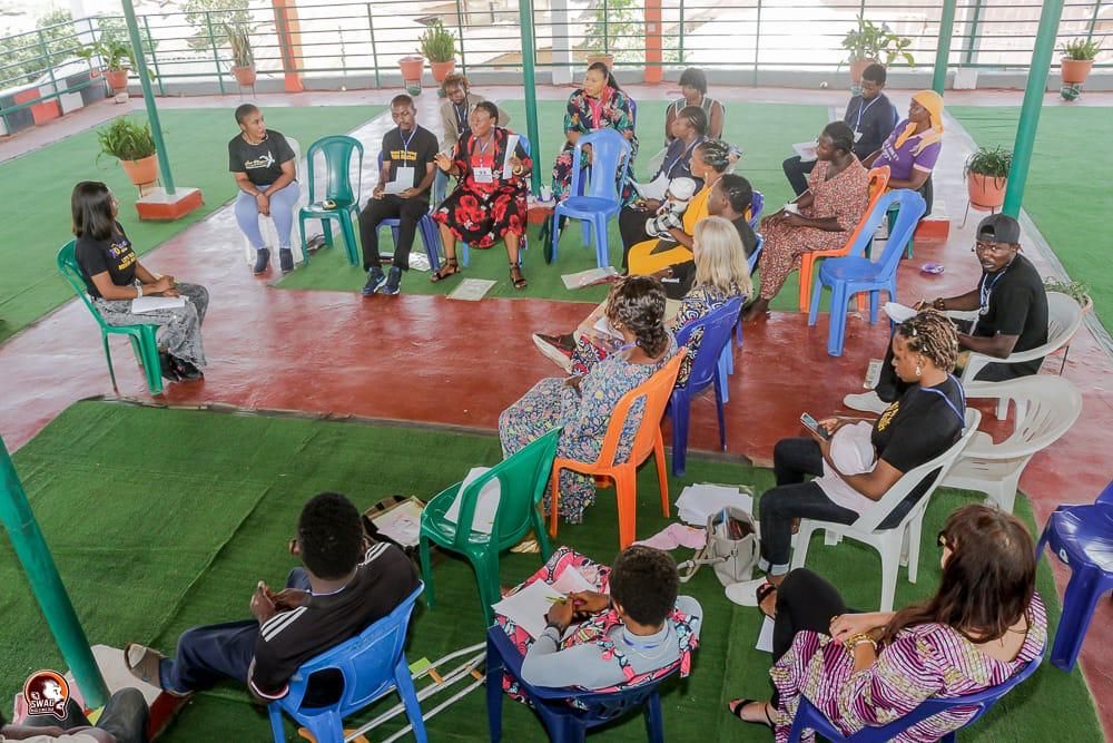 A community peer support circle meeting under an open-air pavilion