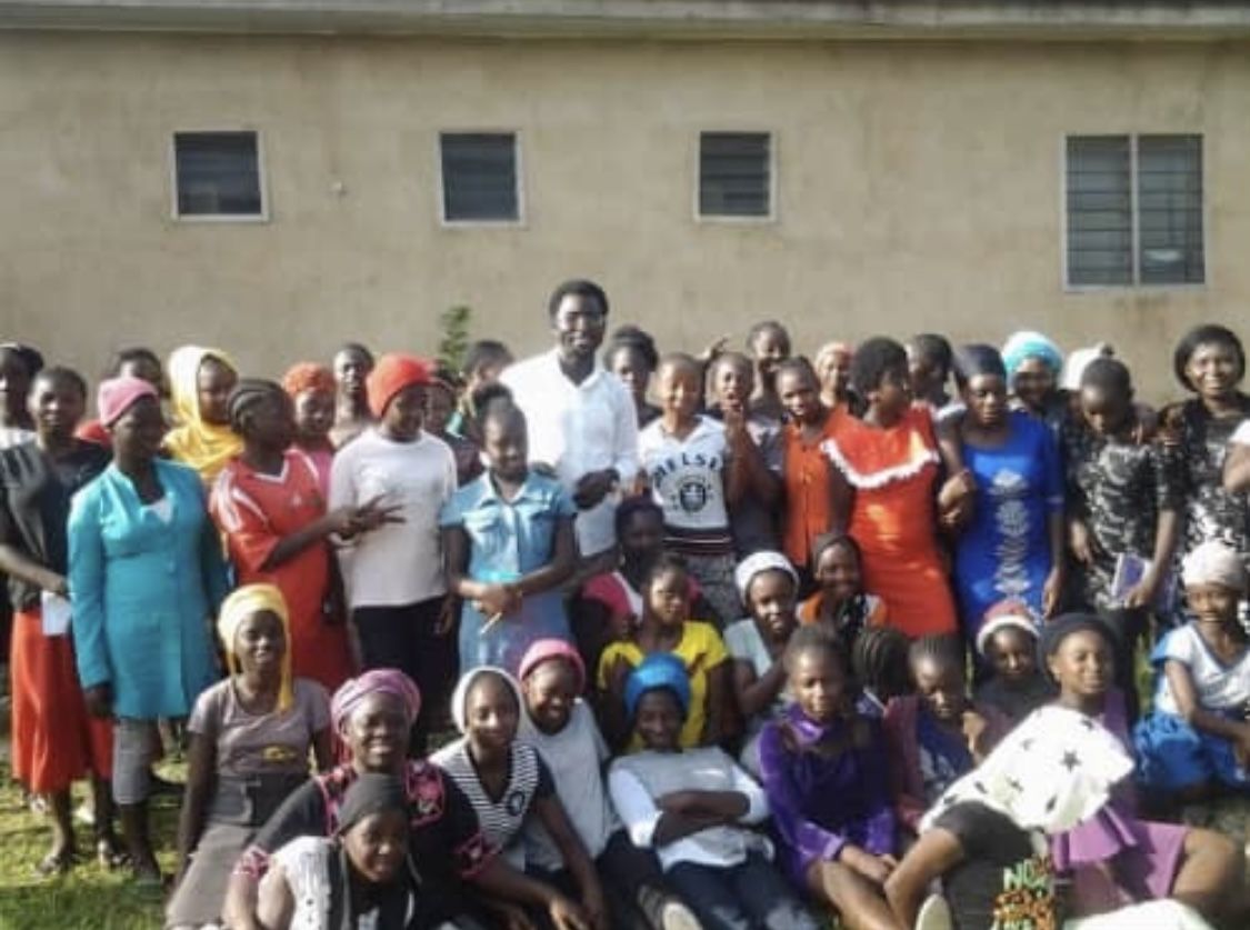 A large group of women gathered outdoors at a community support programme